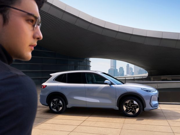 Man walking past a Geely EX5
